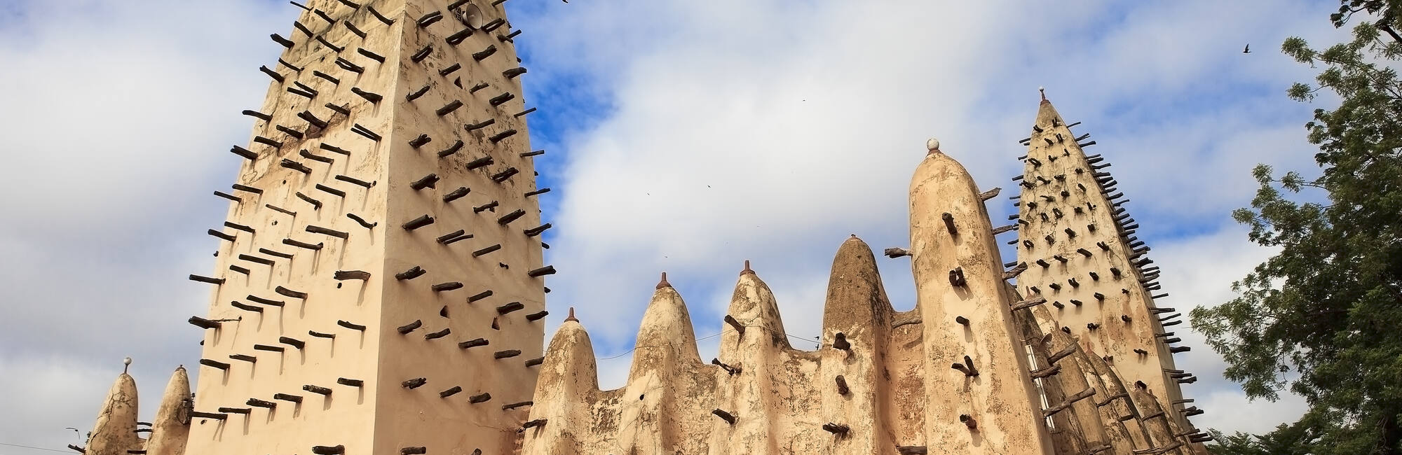 The image shows the Grand Mosque of Bobo-Dioulasso in Burkina Faso, a prominent example of Sudano-Sahelian architecture. 