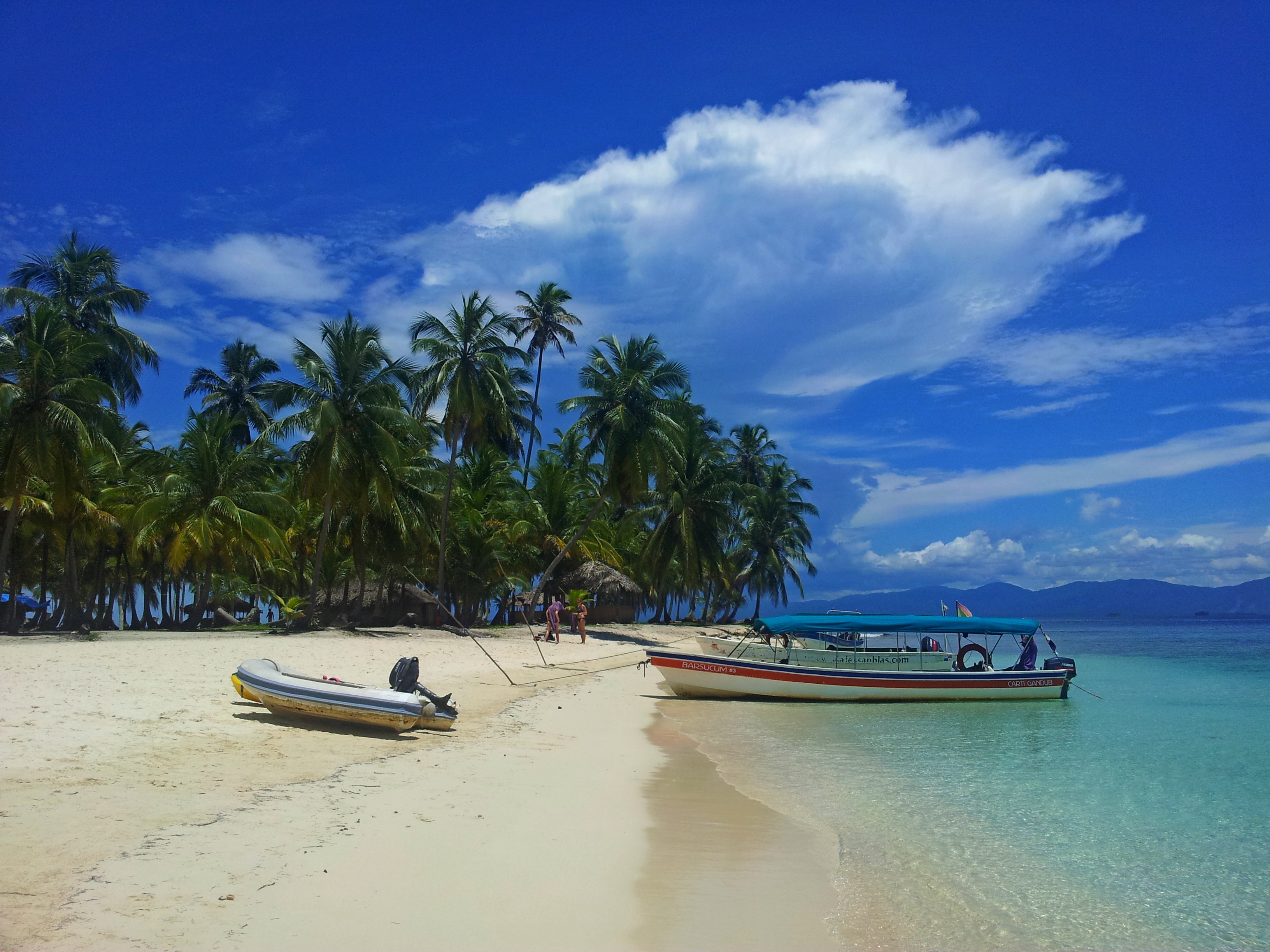 Boats on the shore of a white sand Panama beach 