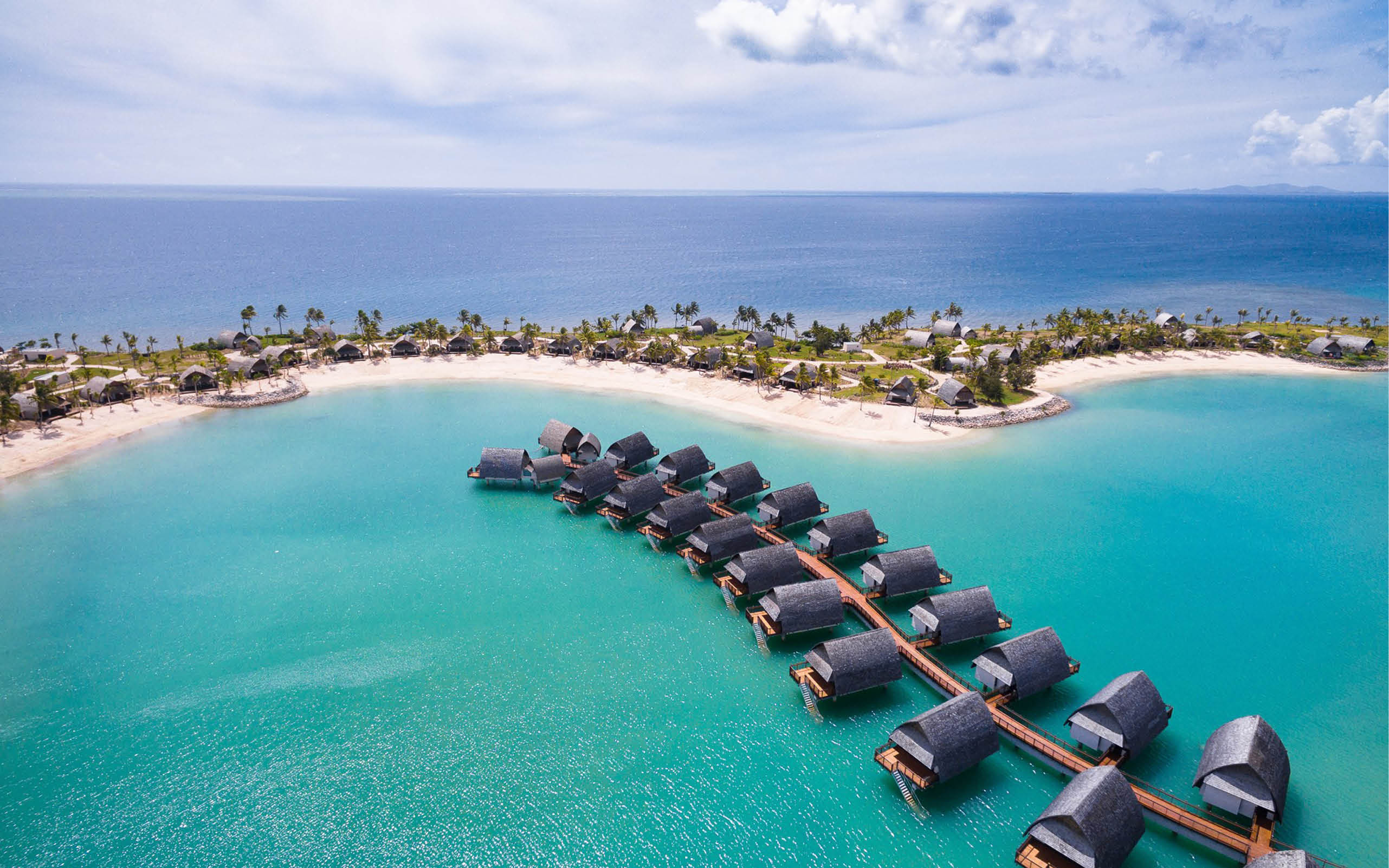 Villas on the blue ocean by a sandy beach in Fiji