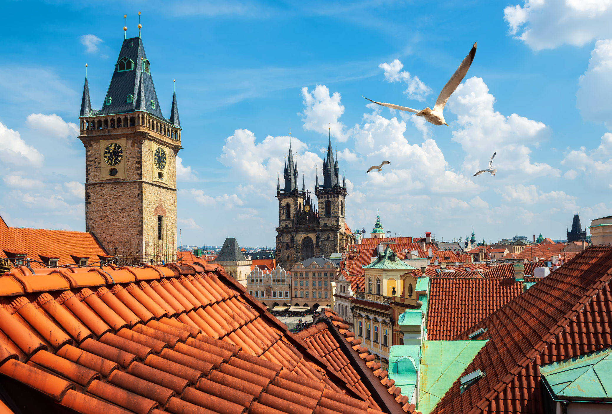Orange tile rooftops in Czechia, a castle in the background 