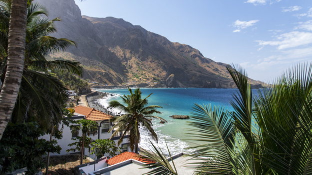 A view of the beach, mountains, and palm trees in Cabo Verde