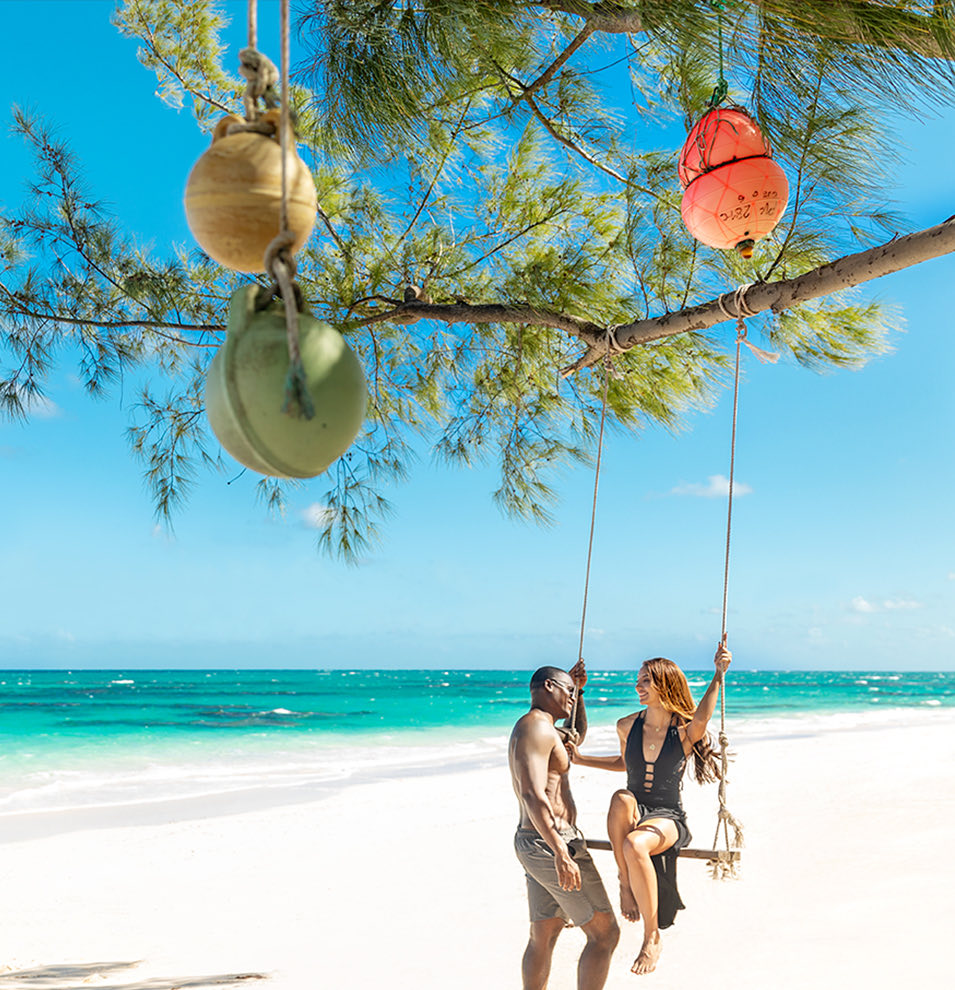 A couple on a swing at the beach at Cat Island